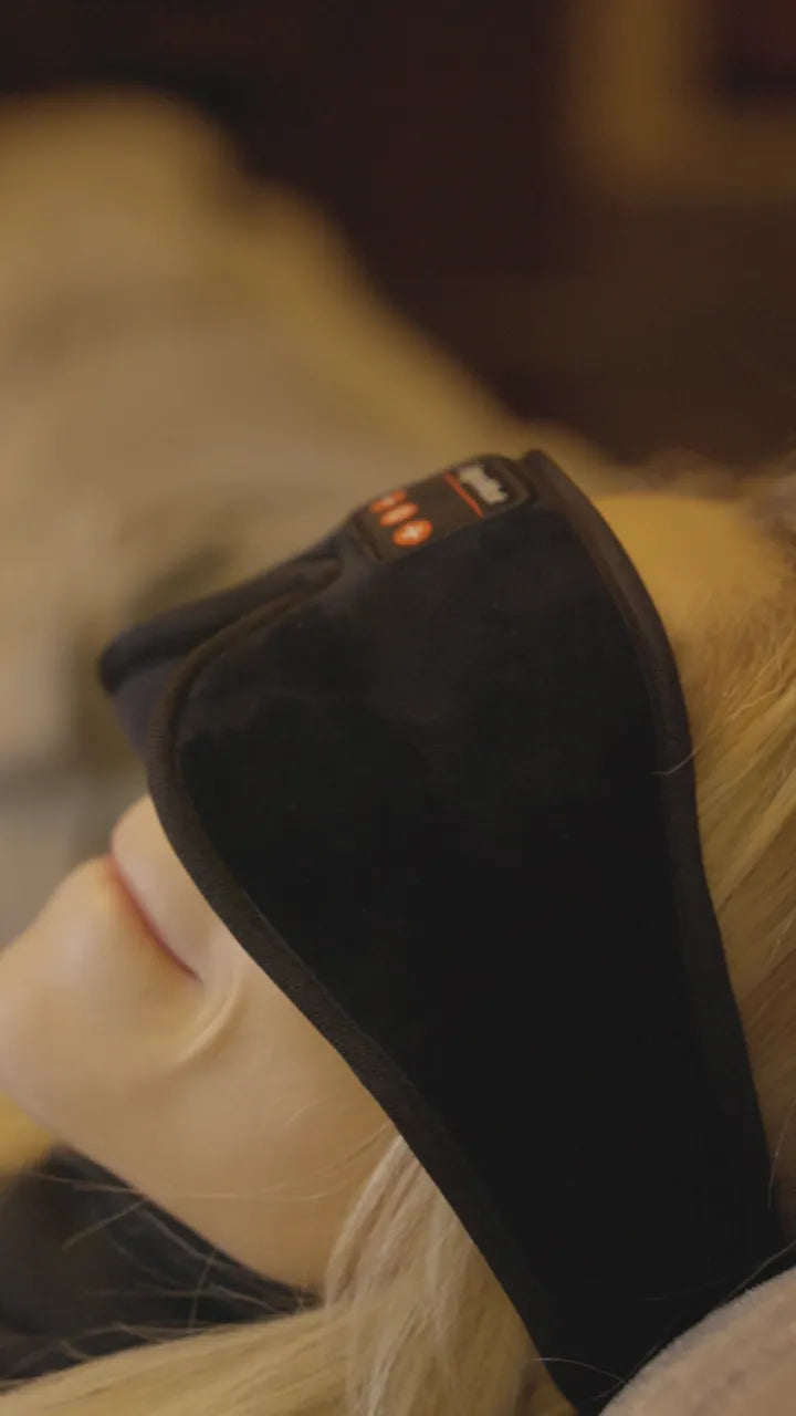 A person lying back with the mask on, in a dark room