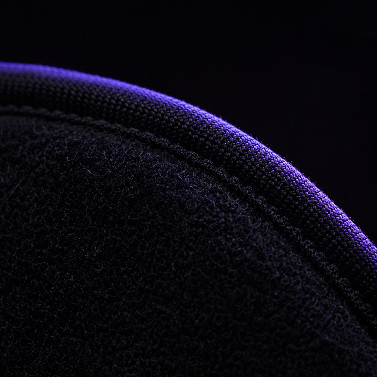 The ORGASMASK v2.4 mask lit by a violet rim light against black